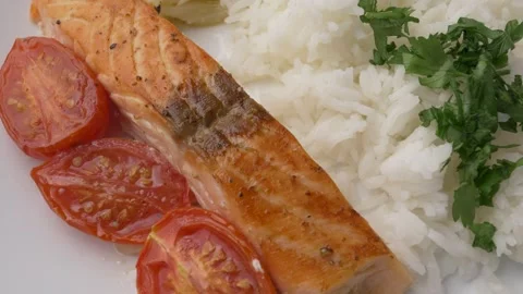 A top view close-up of baked salmon with tomatoes and rice 库存影片 295451414