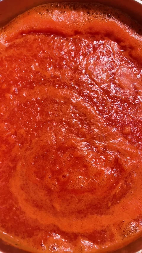 Top view close up of boiling red tomato juice with bubbles in a pot. Video stock 348446535