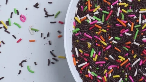 Top view close up of chocolate sprinkles in spinning white plate 库存影片 280453765