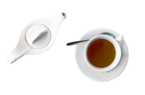 Top view close up of a cup of black tea and kettle, on white table Stock Photos