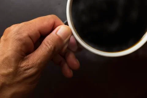 Top view close up hand man hold coffee cup . Black coffee in coffee cup. Stock Photos