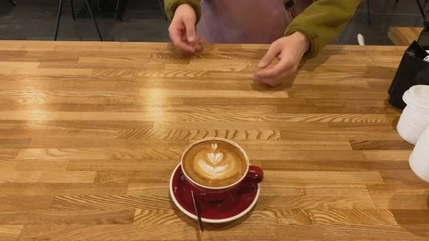 Top view. Close up of hand taking coffee of red cup on wood table. Coffee art Stock Footage 123553261