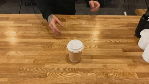 Top view. Close up of hand taking coffee of cup on wood table. Coffee art latte Video stock 123553286