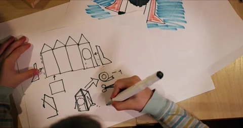 Top view close-up, hands of creative little boy child drawing space rocket Stock Footage 157360966