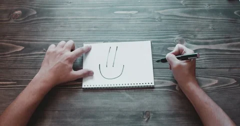 Top view, close-up hands of a man, dad drawing a smile Video stock 260938806