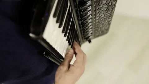 Top view. Close-up of a man's right hand playing on a black accordion. Stock Footage 76113602