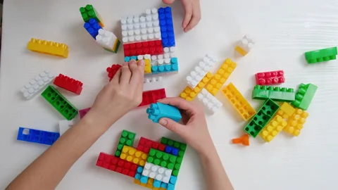 Top view close up of mother and little daughter kid play colorful plastic bricks Stock Footage 166306501
