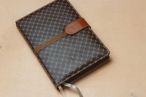 Top view of close up notebook dark cover on bright desk background Stock Photos