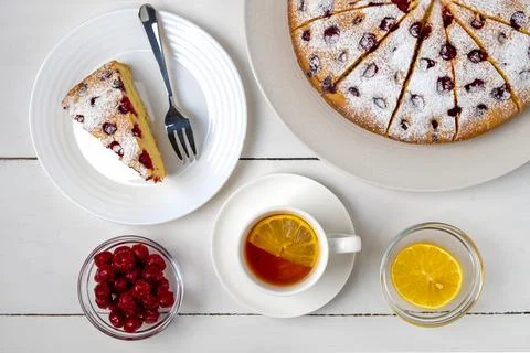 Top view close-up of sliced cherry pie, slice of pie on a plate and lemon tea Stock Photos