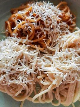 Top View Close Up of Spaghetti Varieties Topped with Grated Cheese Stock Photos