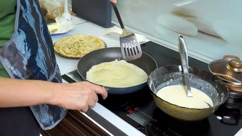 Top view close-up view of female hand flipping pancake on frying pan. Stack of c Stock Footage 99044344
