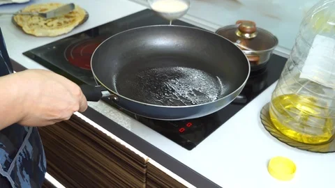 Top view close-up view of female hand flipping pancake on frying pan. Stack of c Stock Footage 99045714