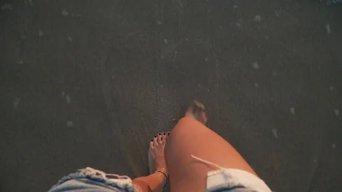 Top view close-up woman's legs in sea at sunset Stock Footage 114073360