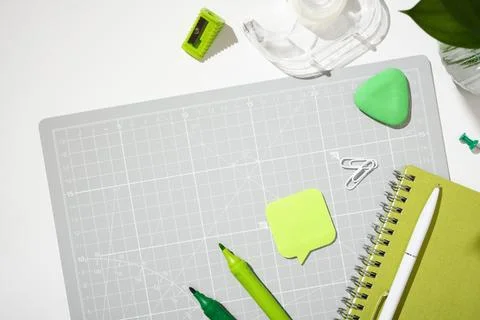 Top view of a closed green notebook, speech bubble sticky note, and markers o Stock Photos