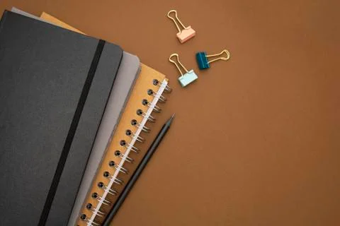 Top view of closed notebooks, with pencil on brown desk background with copy  Foto stock