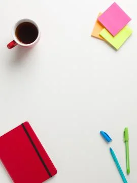 Top view of a closed red notebook, colored reminders, blue and green pen, a r Stock Photos