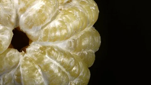 Top view of closely peeled huge pomelo, rotating clockwise on black background Stock Footage 78355222
