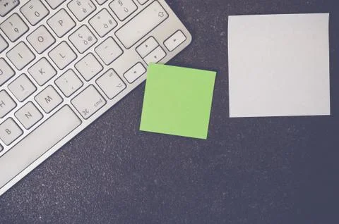 A top view closeup of a computer keyboard with sticky notes on a stone textur Foto stock