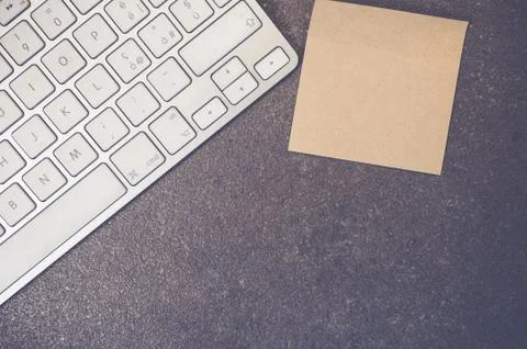 A top view closeup of a computer keyboard with sticky notes on a stone textur Foto stock