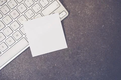 A top view closeup of a computer keyboard with sticky notes on a stone textur Foto stock