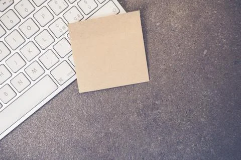 A top view closeup of a computer keyboard with sticky notes on a stone textur Foto stock