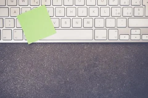 A top view closeup of a computer keyboard with sticky notes on a stone textur Foto stock