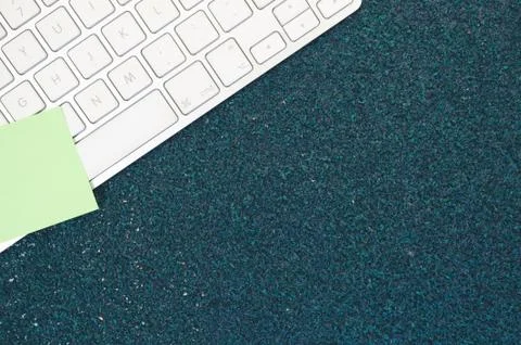 A top view closeup of a computer keyboard with sticky notes on a stone textur Foto stock