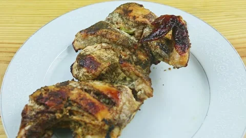 Top view closeup on man by hand moves white plate with half of baked chicken Stock Footage 143556129