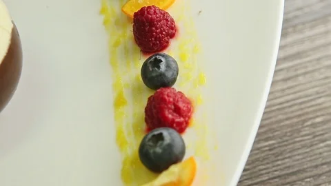 Top view closeup row of blueberry, raspberry and orange rotates on plate Stock Footage 121804994