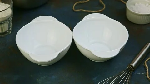 Top view closeup small on two small empty white bowls stand on kitchen table Video stock 132336508
