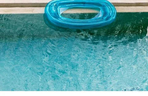 Top view closeup of turquoise inflatable ring floating on swimming pool wat.. Stock Photos
