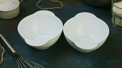Top view closeup on two small empty white bowls stand on dark kitchen table Video stock 134485335