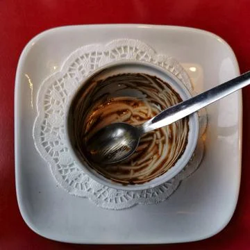 A top view closeup view of an empty white bowl of a chocolate mousse on a red Stock Photos