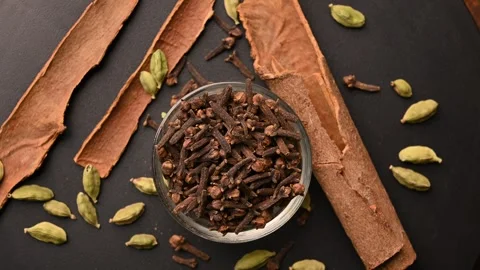 Top View of Cloves (Laung) in White Bowl with Cinnamon Sticks Stock Footage 329358019