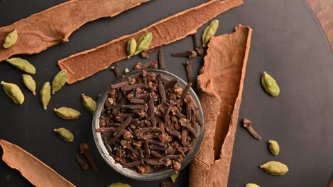 Top View of Cloves (Laung) in White Bowl with Cinnamon Sticks Stock Footage 329358083