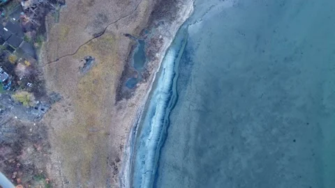 Top view of the coast, the sea is calm, near the water there are buildings Видео 164072415