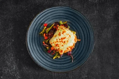 Top view of cod fillet baked with cheese topping served with fried beet, carr Stock Photos