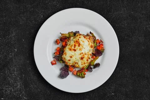 Top view of cod fillet baked with cheese topping served with fried beet, carr Stock Photos