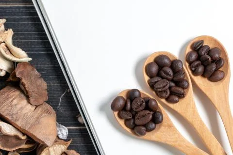 Top view of Coffee beans are placed in a wooden spoon on blank note book and  Stock Photos