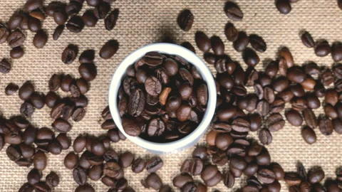 Top view of a coffee beans cup on a jute table background Stockbeeldmateriaal 231123428