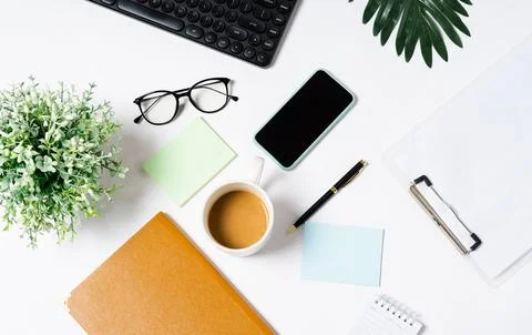 Top view of coffee, book, notebook, pen, keyboard, phone on white background Stock Photos