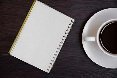 Top view of coffee cup and blank notebook for memo on wooden background. Bu.. Stock Photos
