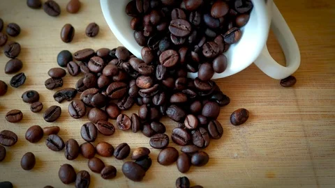 Top view of coffee cup filled with coffee beans on wooden table. Stock Footage 72367663