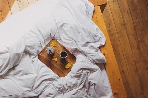 Top view of the coffee maker and cup of fresh coffee on the comfortable bed Stock Photos