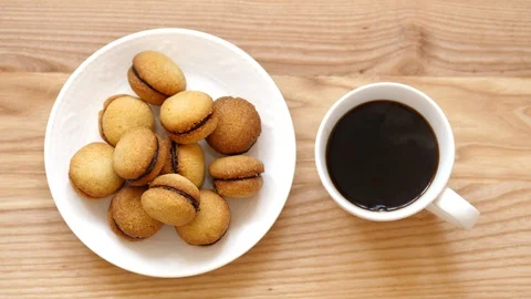 Top view. Coffee is poured into a cup near the plate with cookies Stock Footage 88733809