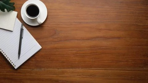 Top view of coffee, sticky note, notebook and pen on wooden table. Copy spa.. Stock Photos