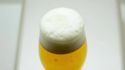 Top View of Cold Beer Glass with Thick White Foam Видео 334693631