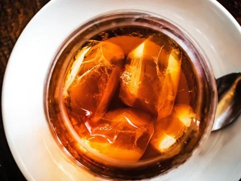 Top view of cold brewed coffee with ice cubes in a clear glass plased on a white Stock Photos