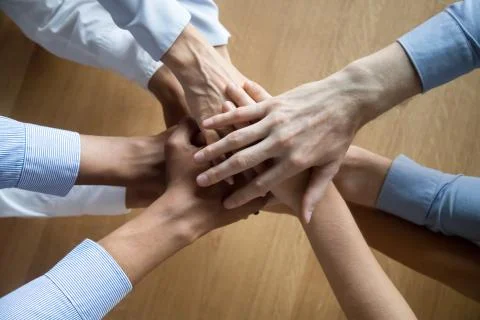 Top view of colleagues join hands motivated for shared success Stock Photos