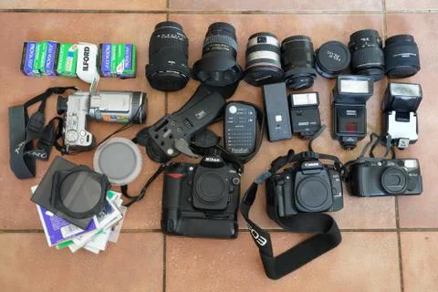 Top view of a collection of old camera gear laid out on a tiled floor Stock Photos